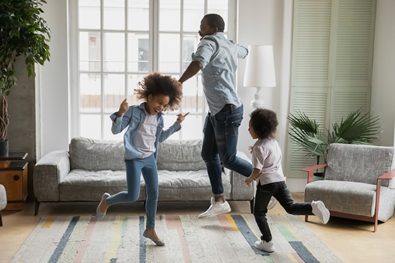 Family dancing in living room.